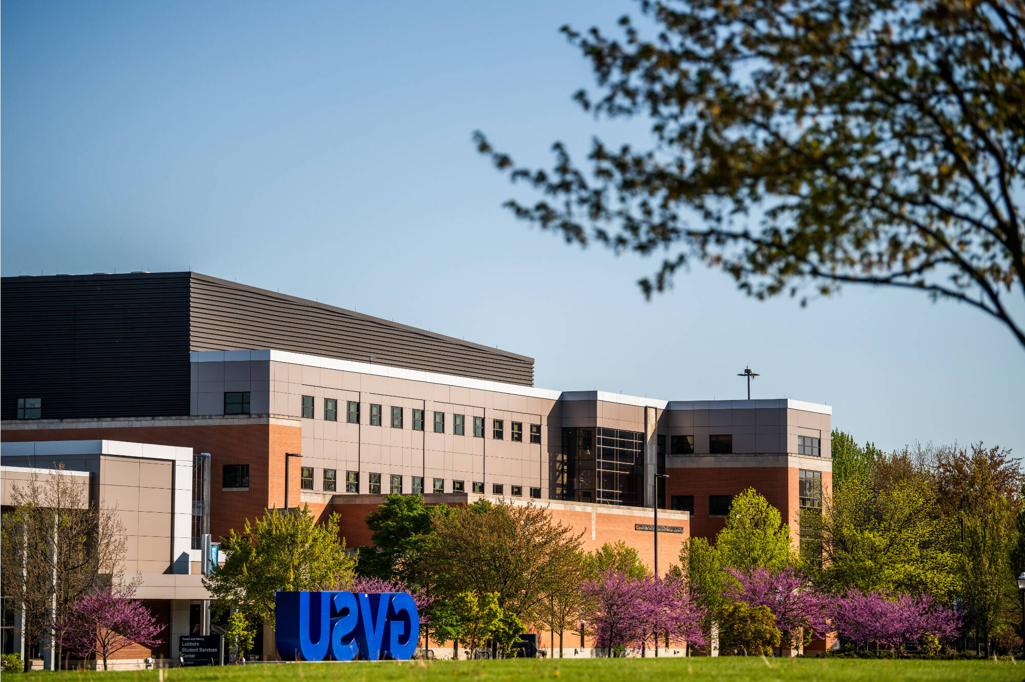 Campus buildings on the GVSU campus from a distance with the GVSU blue letters